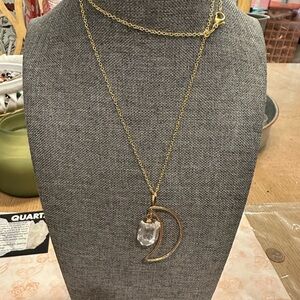 Beautiful crystal quartz stone set in a gold tone moon pendant